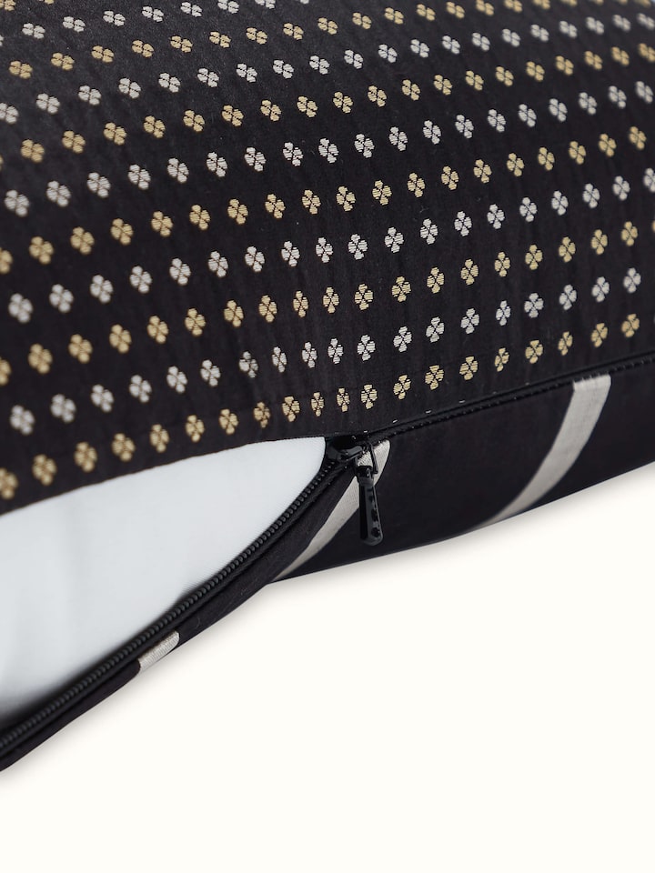 Angled side view of Awadh Banarasi Cushion, featuring black silk with subtle golden stripes.
