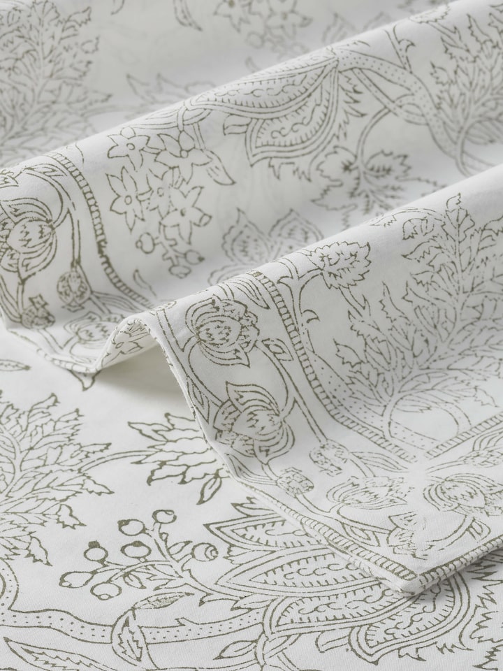 Detail shot of floral hand block print pattern on grey cotton bedsheet fabric