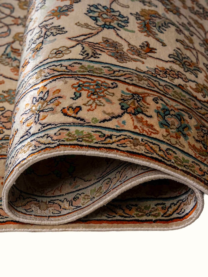 Detail view of Traditional Persian Beige Kashan Kashmir Silk Hand-Knotted Carpet highlighting the intricate pattern and pile texture, from a differ...