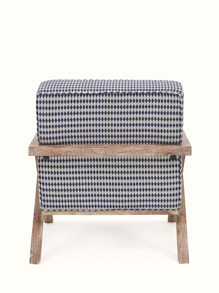 Angled back view of Swadesh Upholstered Acacia Wood Armchair showcasing its comfortable seat and detailed woodwork