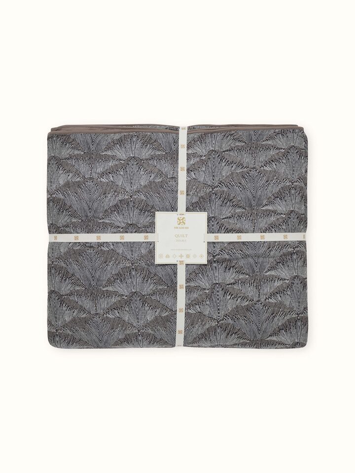 Close-up showing fine Sanganeri detailing on Parvat brown printed quilt fabric.